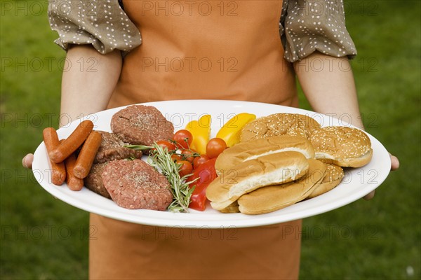 Person holding platter of food for barbeque.