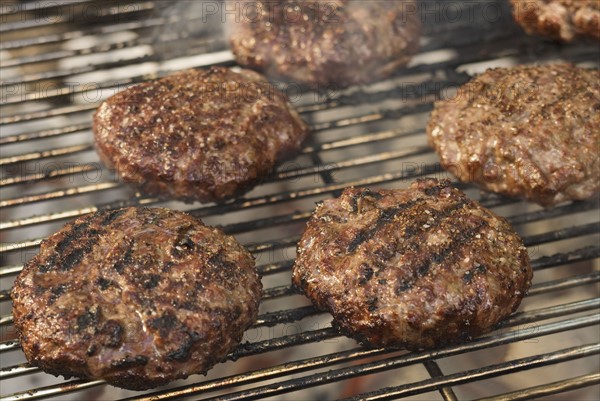 Hamburgers cooking on grill.