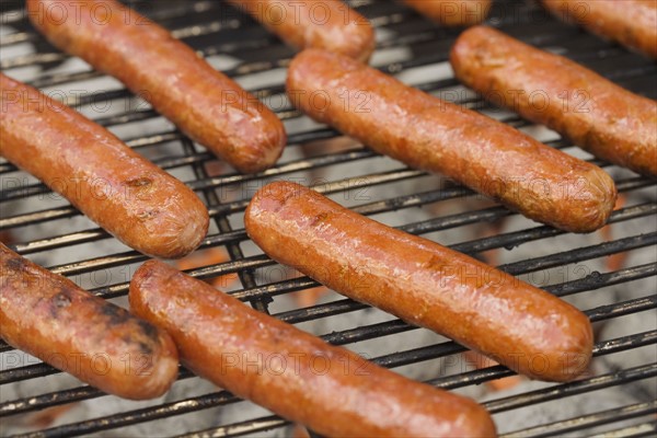 Hot dogs cooking on grill.