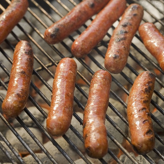 Hot dogs cooking on grill.