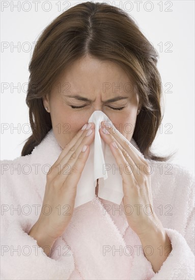 Woman blowing nose.