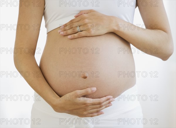 Pregnant woman with hands on belly.