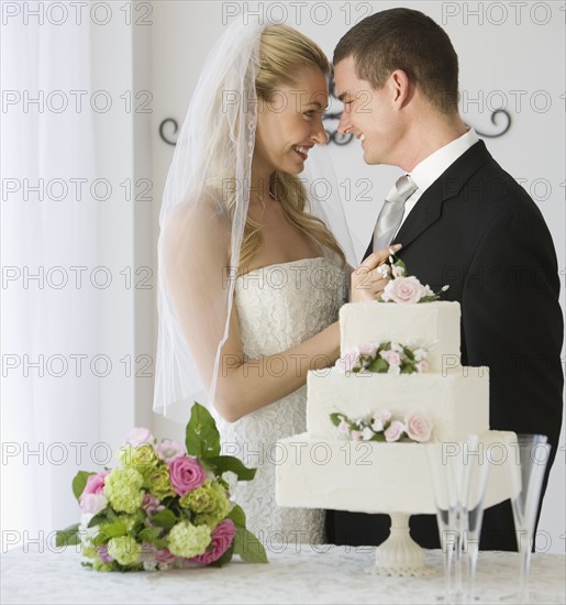 Bride and groom next to cake.