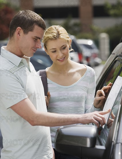 Couple looking at new car.