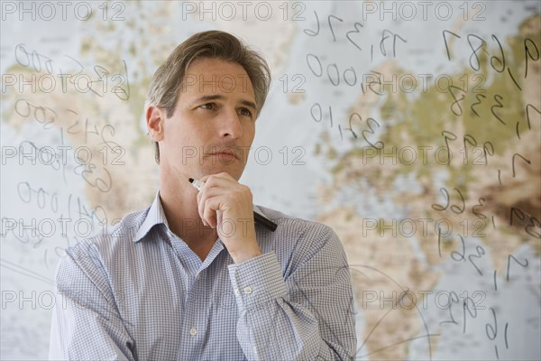 Businessman looking at dry erase board.