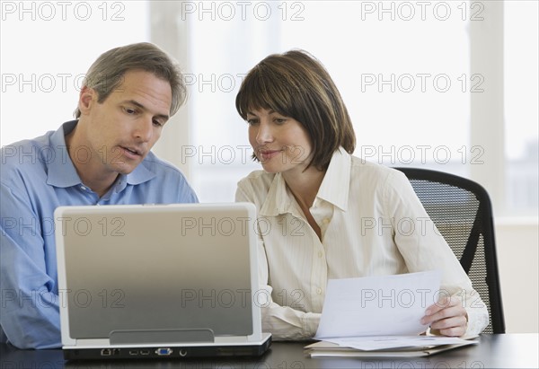 Businesspeople looking at laptop.