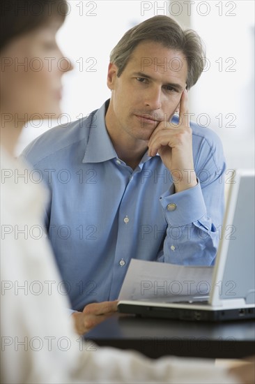 Businessman next to laptop.