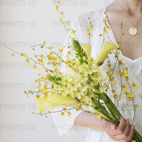 Woman holding bouquet of flowers.