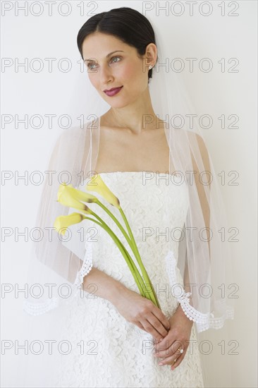 Bride holding long stemmed flowers.