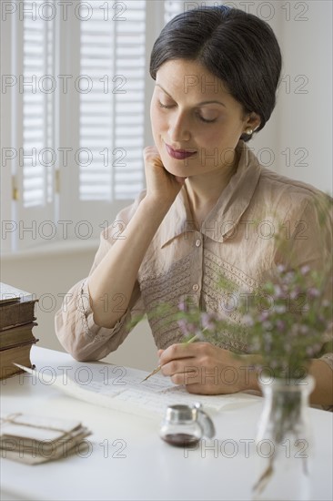 Woman in vintage clothing writing letter.