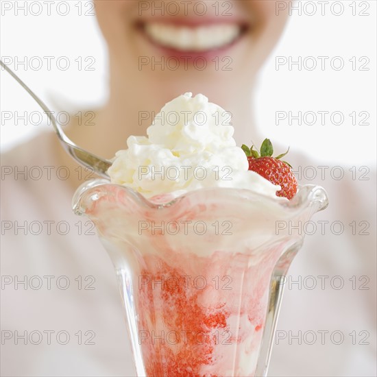 Woman eating strawberry parfait.