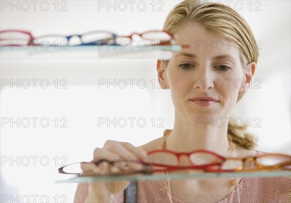 Woman looking at eyeglasses in store.