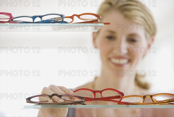 Woman looking at eyeglasses in store.