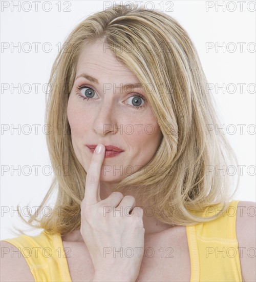 Woman with finger on mouth.