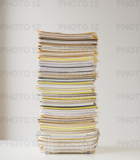 Large stack of paperwork in wire basket.