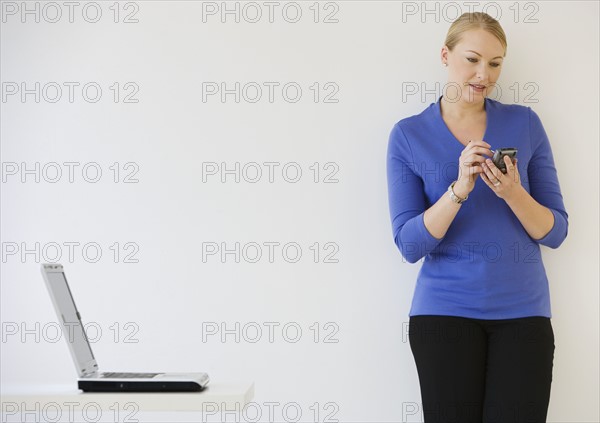 Businesswoman using electronic organizer.