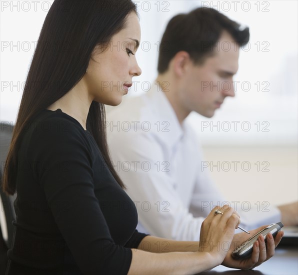 Businesswoman using electronic organizer.