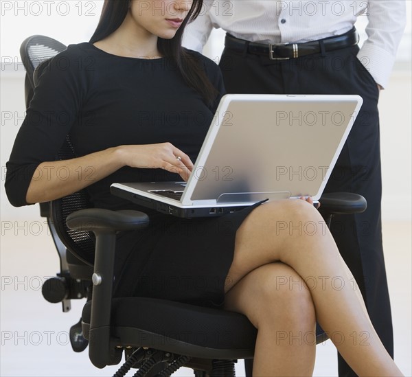Businesswoman typing on laptop.