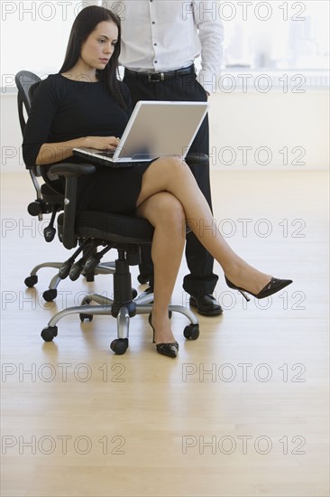 Businesswoman typing on laptop.