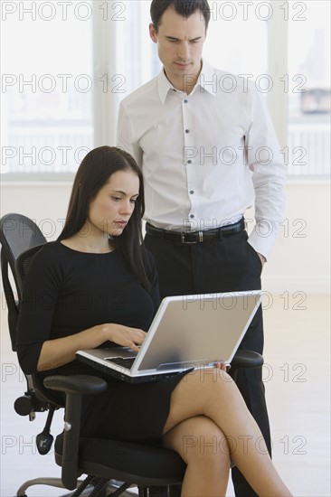 Businesspeople looking at laptop.