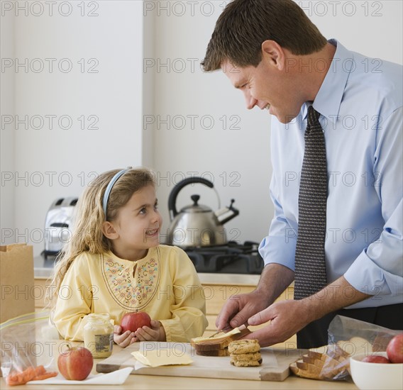 Father and daughter making breakfast.