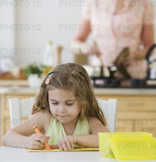 Girl coloring at kitchen table.