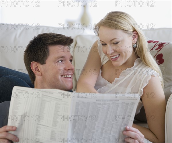 Couple reading newspaper.