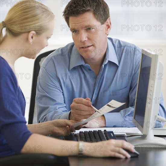 Businesspeople looking at paperwork.