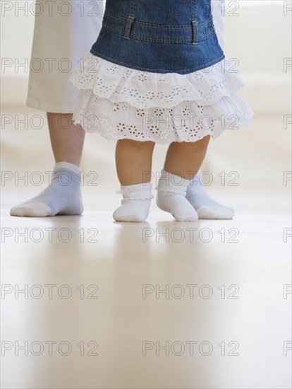 Mother helping baby walk.