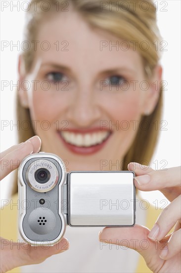 Woman holding small video camera.