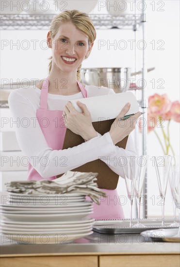 Female caterer holding clipboard.