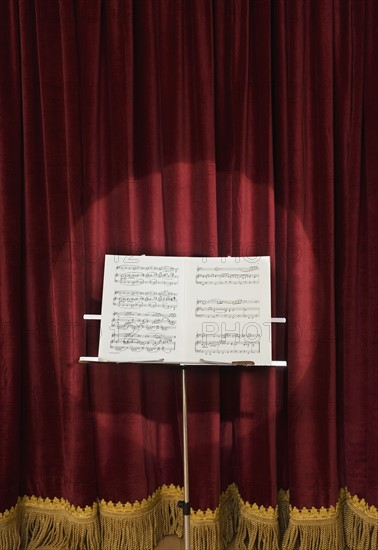 Spotlight on sheet music on stage.