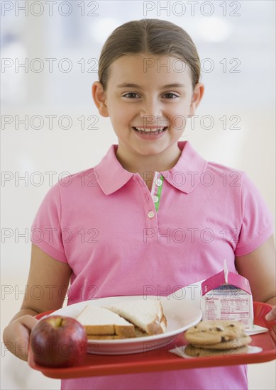 Girl carrying lunch tray.