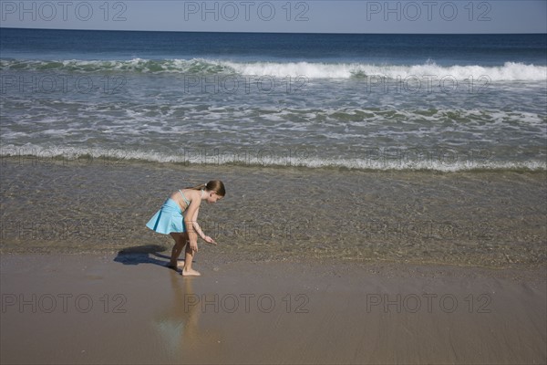 Girl standing in ocean surf.
