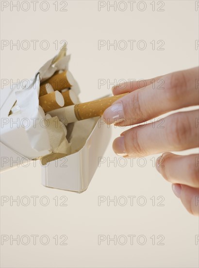 Woman talking cigarette out of pack.