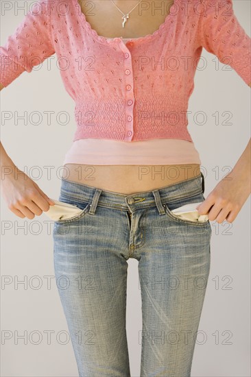 Young woman pulling out pockets.
