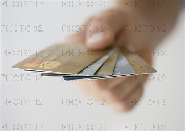 Hand holding fanned out credit cards.
