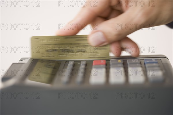 Man swiping credit card in credit card machine.