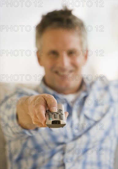 Man pointing television remote control.