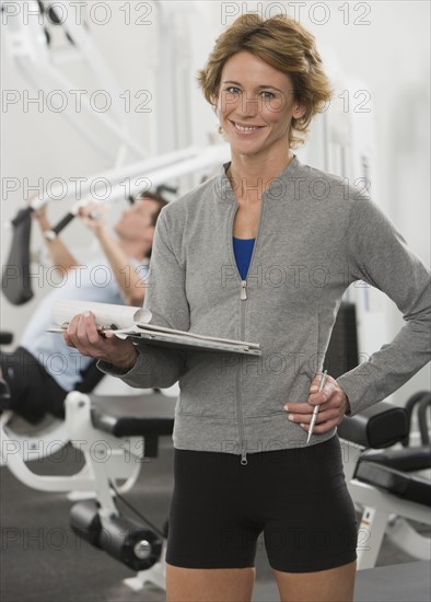Female person trainer holding chart.