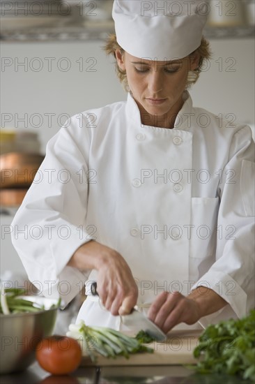 Female chef chopping vegetables.