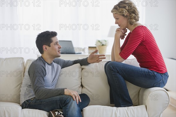 Couple talking on sofa.