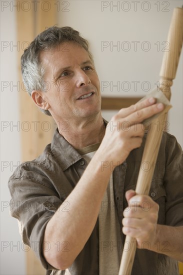 Man sanding piece of wood.