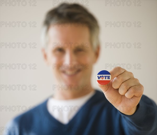 Man holding Vote button.