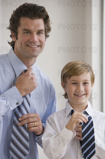 Father and son tying neckties.
