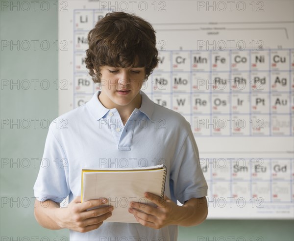 Teenaged boy giving speech in science class.