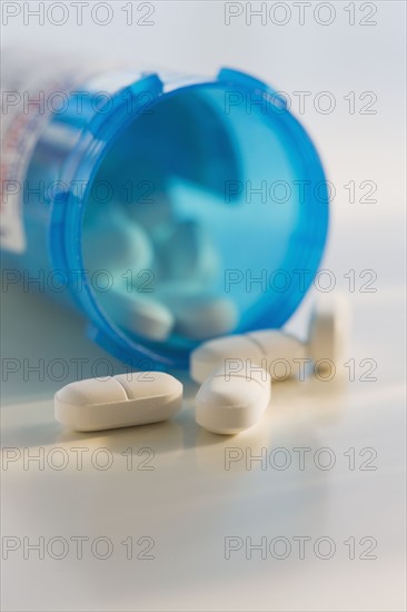 Close up of pills spilling out of bottle.