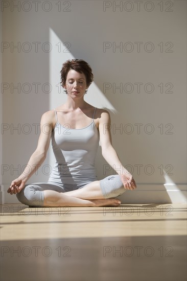 Woman meditating in sunlight.