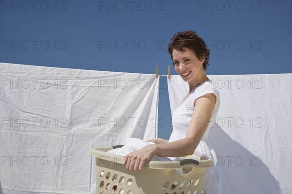 Woman hanging laundry on clothes line.