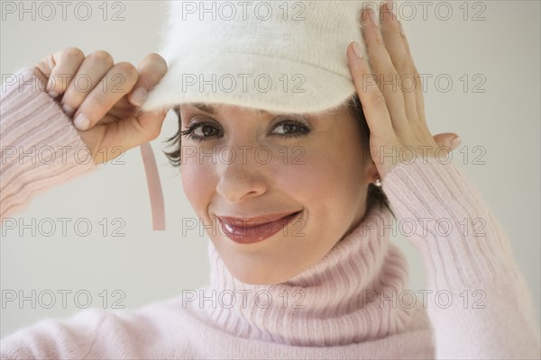 Woman trying on hat.